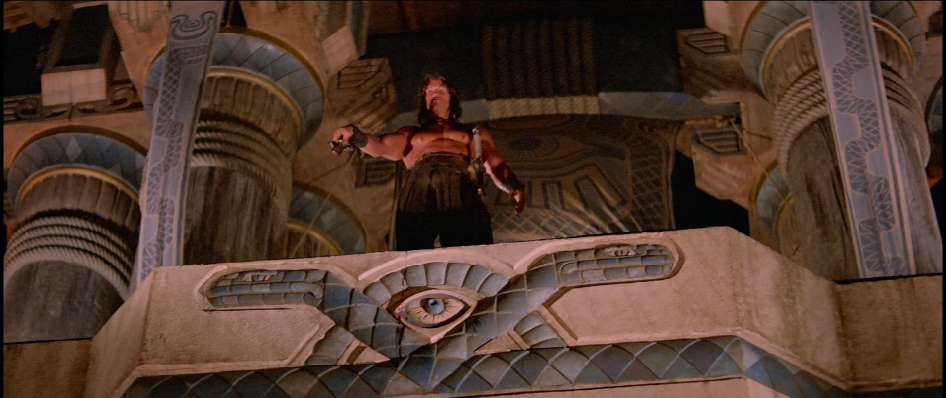 Conan at top of religious pyramid, weird symbols, holding broken sword