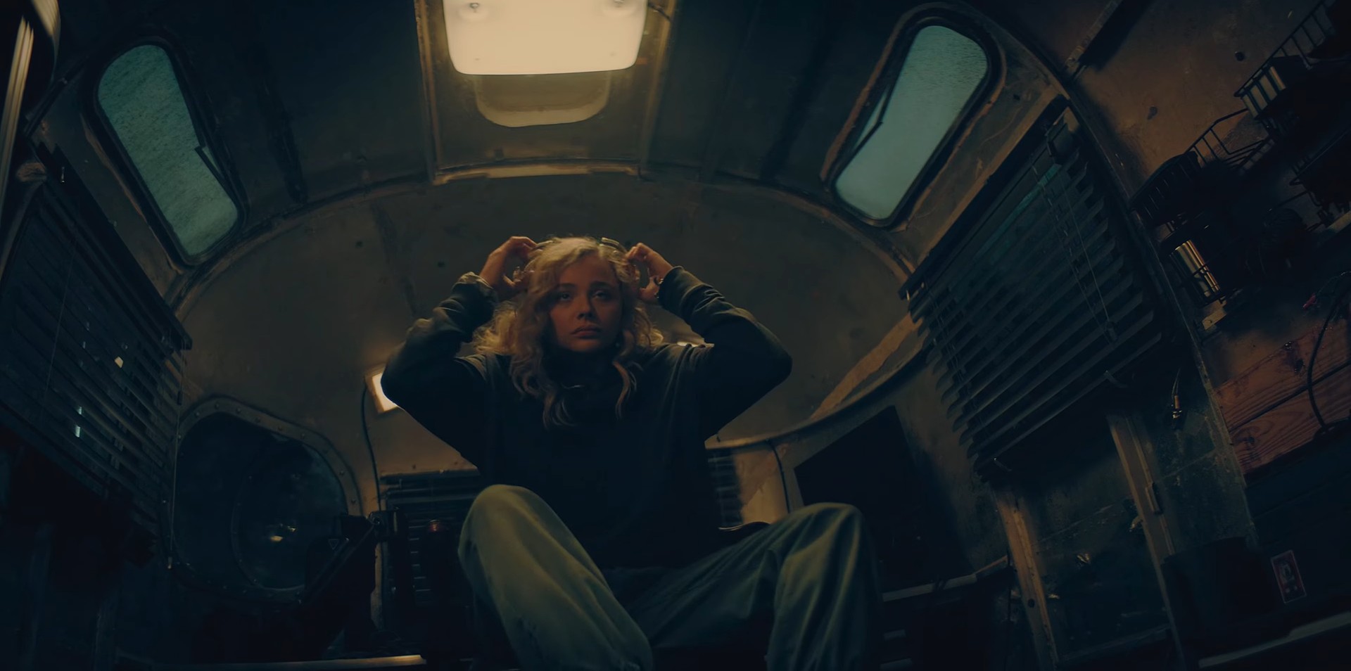 A blond woman sitting in a trailer home feeling sick, vomits